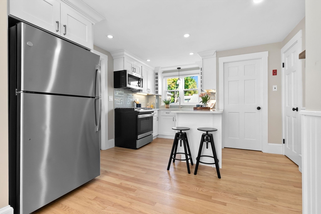17 Coolidge Street Stoneham, MA 02180 - Photo 6 of 37 a kitchen with stainless steel appliances a refrigerator and a stove top oven