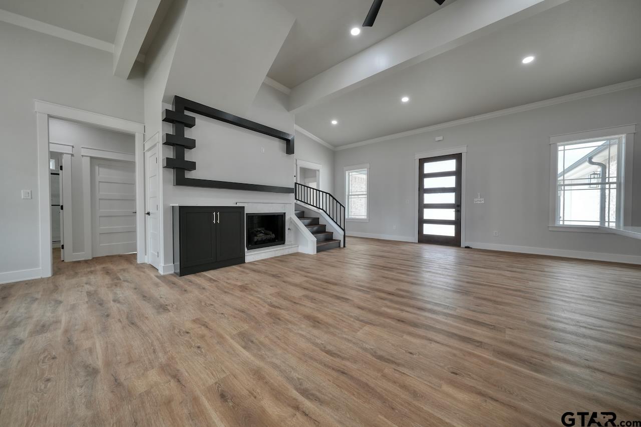 19383 Ridge Point Circle Lindale, TX 75771 - Photo 8 of 48 an empty room with wooden floor fireplace and windows