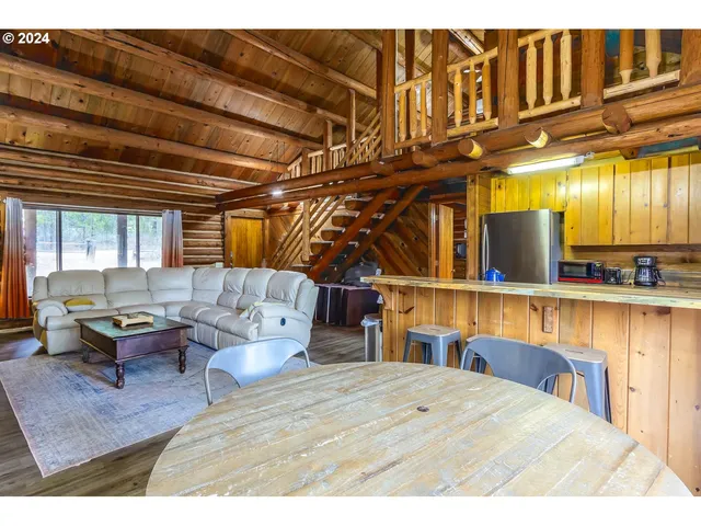 a living room with furniture a rug and kitchen view