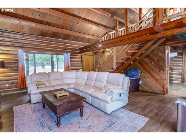 a living room with furniture a wooden floor and next to a window