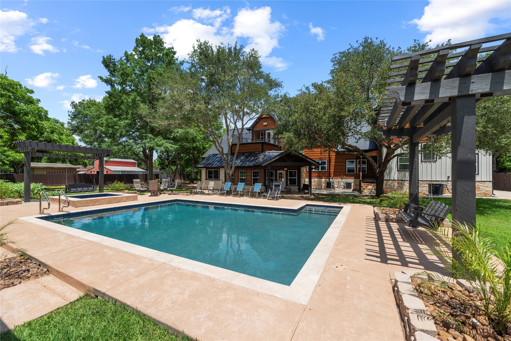 4607 Clayhead Road Richmond, TX 77406 - Photo 43 of 49 Resort-style outdoor living designed for elevated entertaining, featuring a sparkling pool, expansive patio spaces, and a private retreat surrounded by mature trees and timeless architecture.