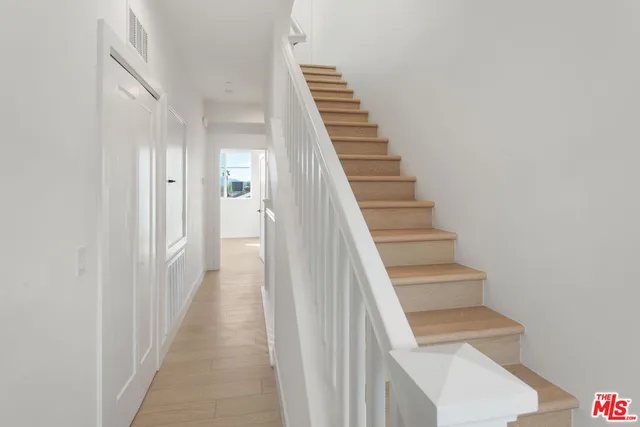 a view of a hallway with wooden floor and entryway