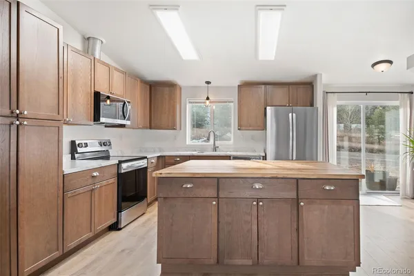 a kitchen with cabinets appliances a sink and a window
