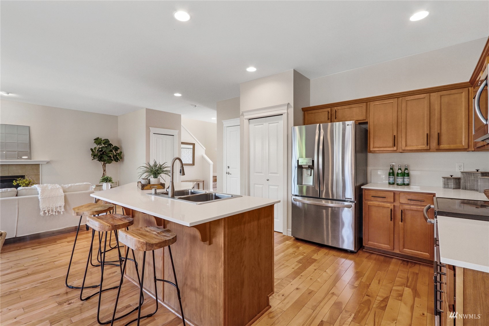 4203 167th Place Southeast Bothell, WA 98012 - Photo 13 of 38 a kitchen with stainless steel appliances kitchen island granite countertop a refrigerator a stove a sink dishwasher and white cabinets with wooden floor
