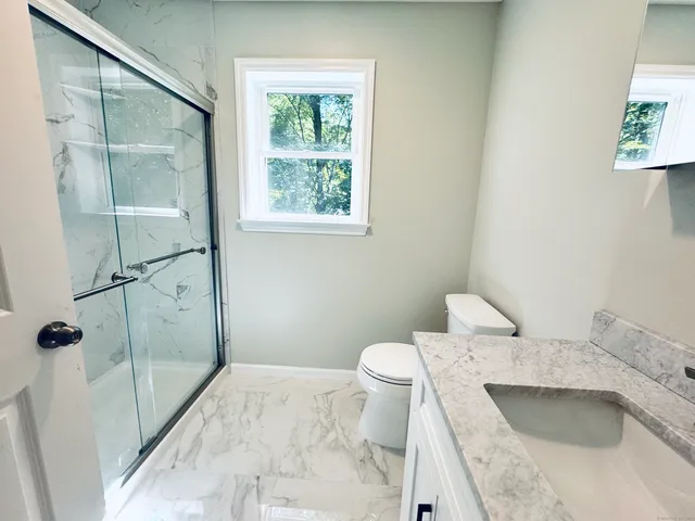 a bathroom with a sink toilet and shower