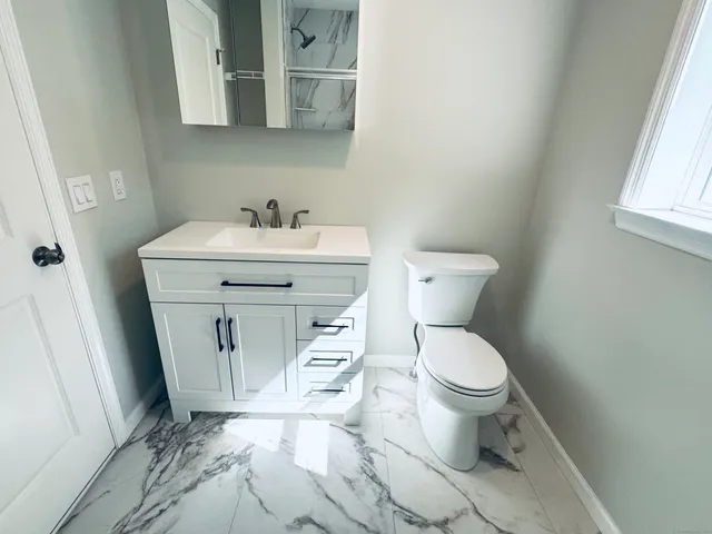 a white toilet sitting next to a bathroom sink