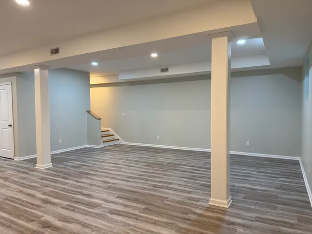 a view of empty room with wooden floor