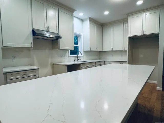 a kitchen with stainless steel appliances a sink a stove a refrigerator and cabinets
