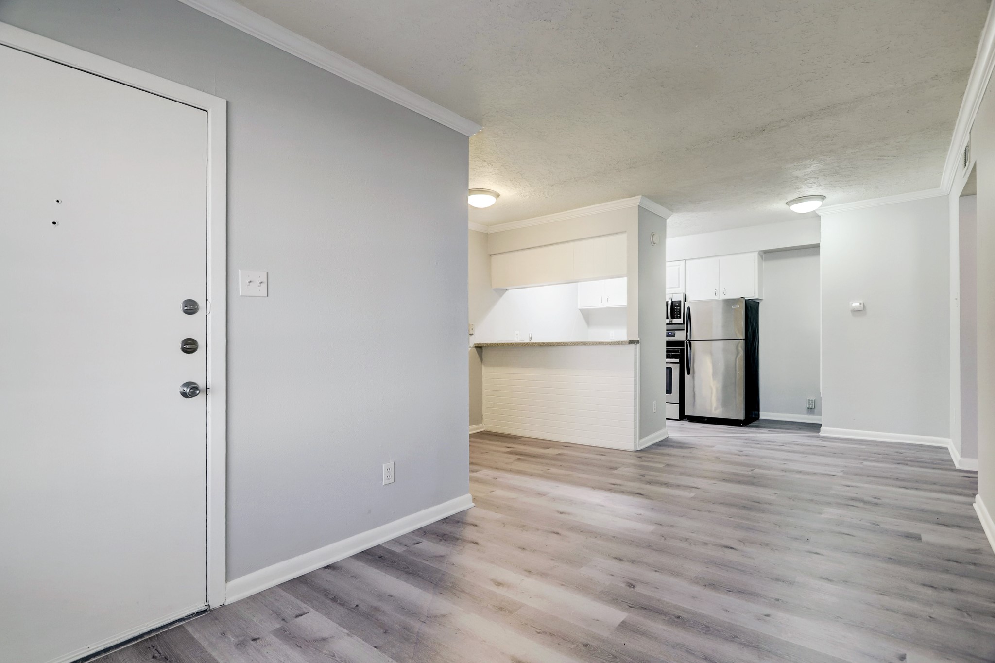 1645 West Main Street, Unit 13 Houston, TX 77006 - Photo 4 of 13 a view of a refrigerator in kitchen and wooden floor