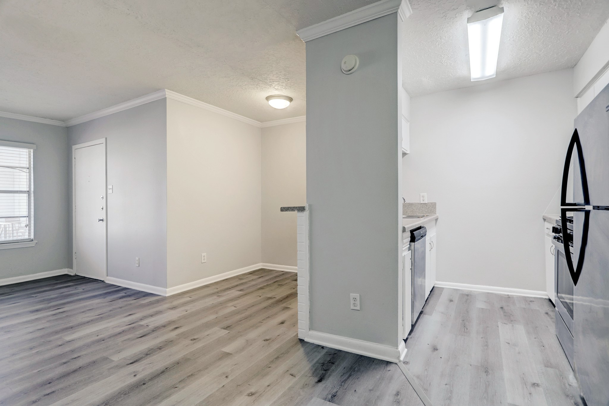1645 West Main Street, Unit 13 Houston, TX 77006 - Photo 6 of 13 an empty room with wooden floor and a ceiling fan