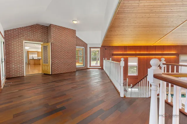 a view of empty room with wooden floor and fireplace