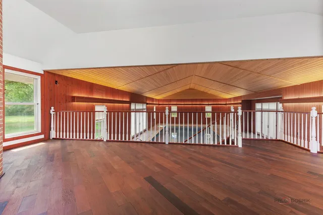 a view of a hall with wooden floor and a kitchen