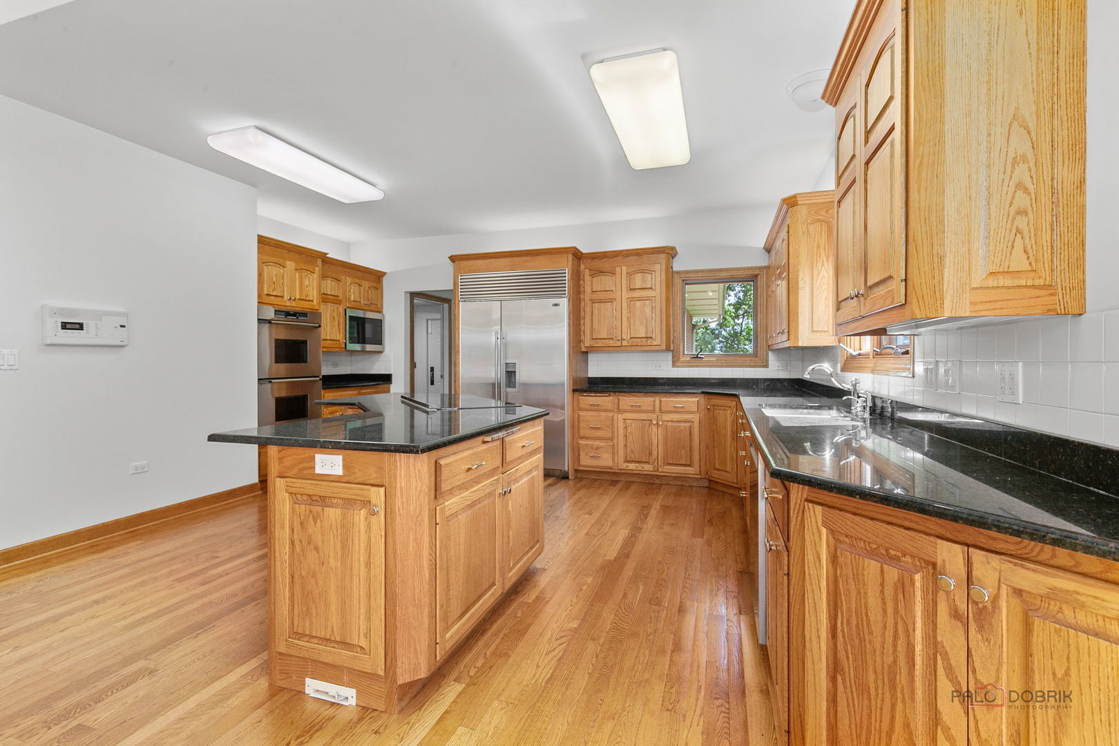 28232 North Gilmer Road Grayslake, IL 60030 - Photo 20 of 74 a kitchen with stainless steel appliances granite countertop a sink a stove and a wooden floors
