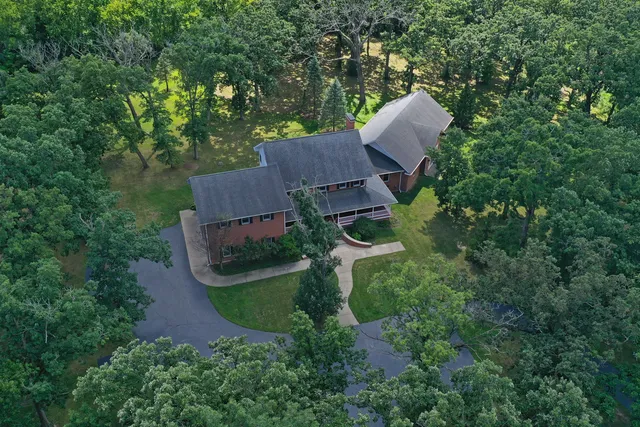 an aerial view of a house with yard and outdoor seating