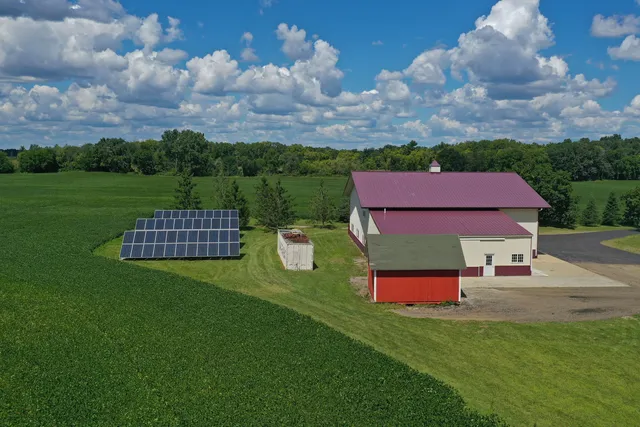 an aerial view of a house with pool fire pit and yard