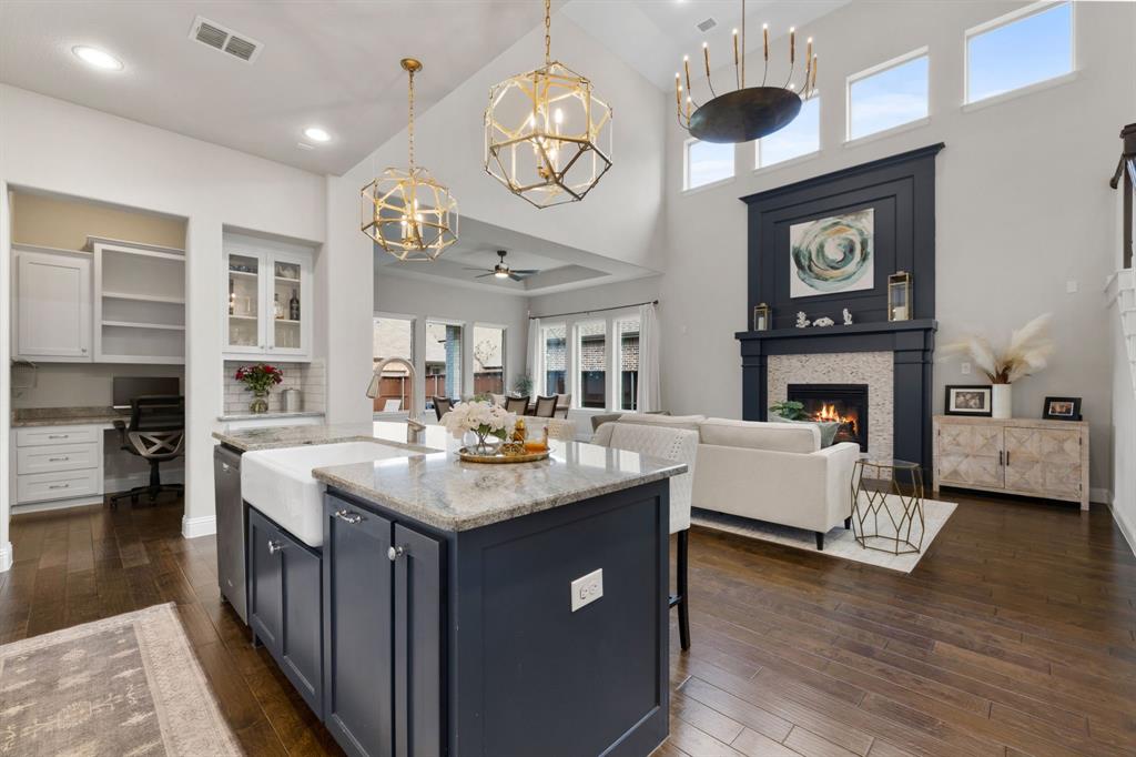 1806 Evening Star Road Frisco, TX 75033 - Photo 2 of 38 Kitchen with decorative light fixtures, dishwasher, white cabinets, a tiled fireplace, and a center island with sink