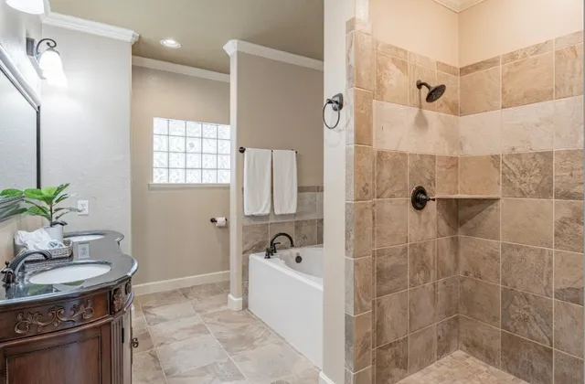 a bathroom with a granite countertop sink a mirror a bathtub and shower