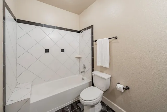 a white toilet sitting next to a bath tub and a shower