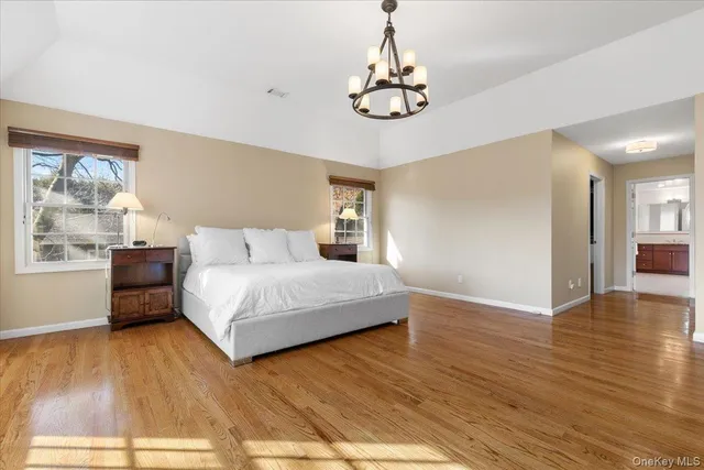 a spacious bedroom with a bed and wooden floor