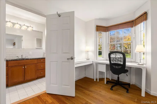 a view of a bathroom with mirror window and wooden floor