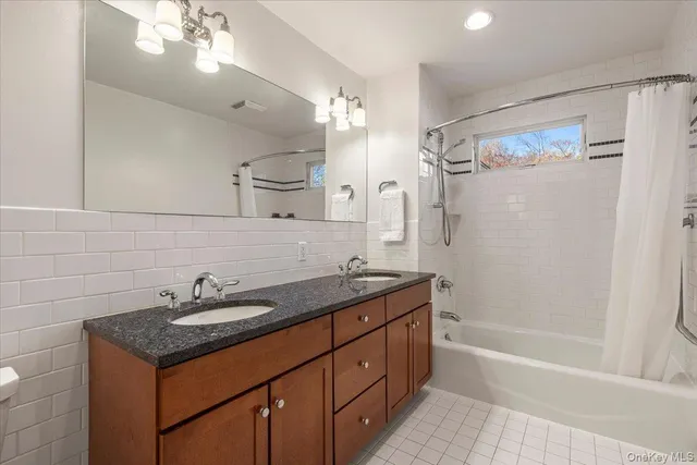a bathroom with a granite countertop sink a toilet a mirror a vanity and shower