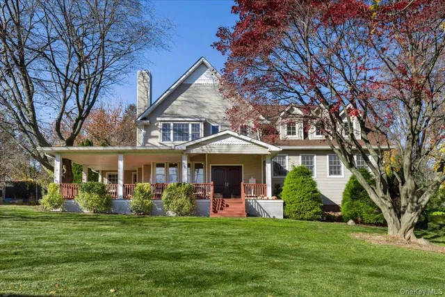 a front view of a house with a garden and trees