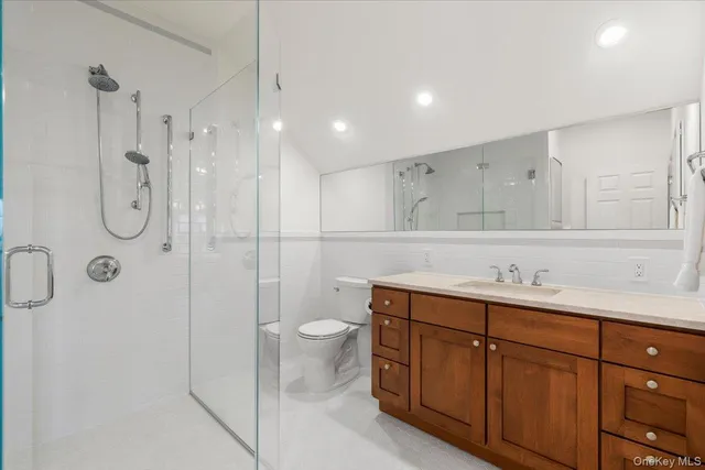 a bathroom with a shower sink vanity and toilet