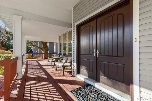 a view of a balcony with chairs and door