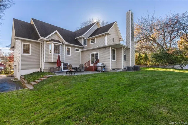 a view of a big house with a big yard and large trees