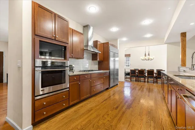a kitchen with stainless steel appliances granite countertop a stove and a wooden floors