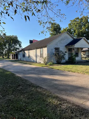 a view of house with yard and parking