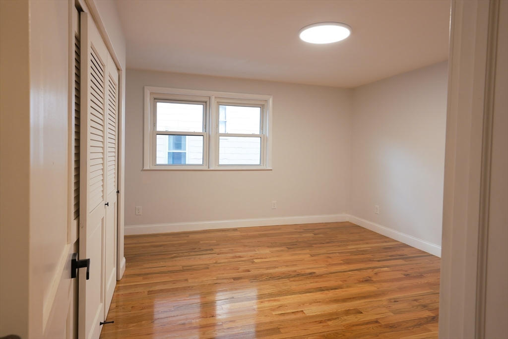 262 East Eagle Street, Unit 2 Boston, MA 02128 - Photo 12 of 24 an empty room with wooden floor and windows