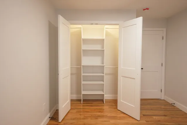 a view of walk in closet with empty racks