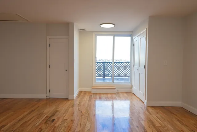 a view of empty room with wooden floor