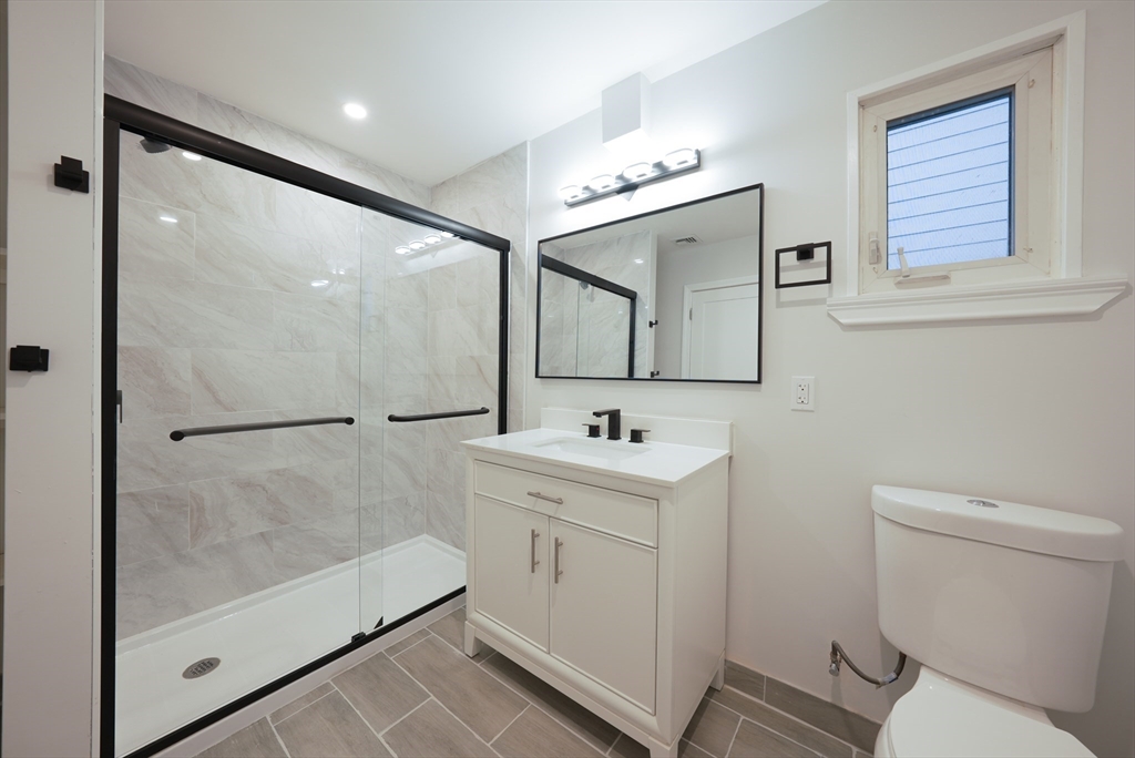 262 East Eagle Street, Unit 2 Boston, MA 02128 - Photo 9 of 24 a bathroom with a toilet a sink and mirror