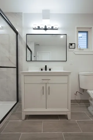 a bathroom with a sink a toilet and mirror