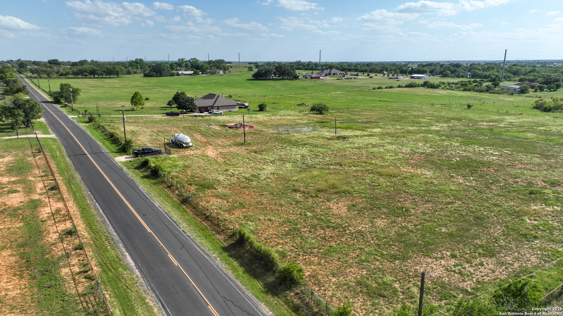 12725 Wisdom Road Atascosa, TX 78002 - Photo 3 of 18 a view of a lush green yard with two chairs