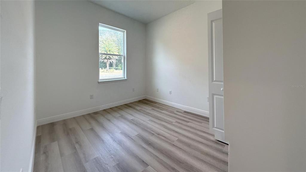 2018 West Magenta Drive Citrus Springs, FL 34434 - Photo 13 of 19 a view of an empty room with wooden floor and a window