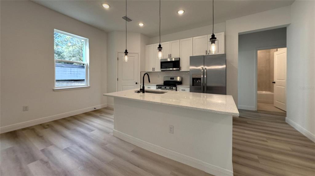 2018 West Magenta Drive Citrus Springs, FL 34434 - Photo 16 of 19 a kitchen with kitchen island white cabinets and stainless steel appliances