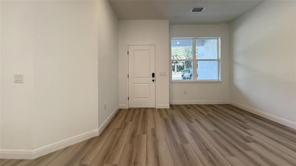 2018 West Magenta Drive Citrus Springs, FL 34434 - Photo 19 of 19 an empty room with wooden floor and windows