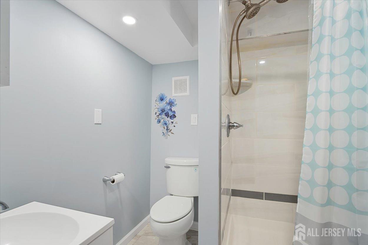 580 Schuyler Way Union, NJ 07083 - Photo 22 of 30 a bathroom with a toilet a sink and shower