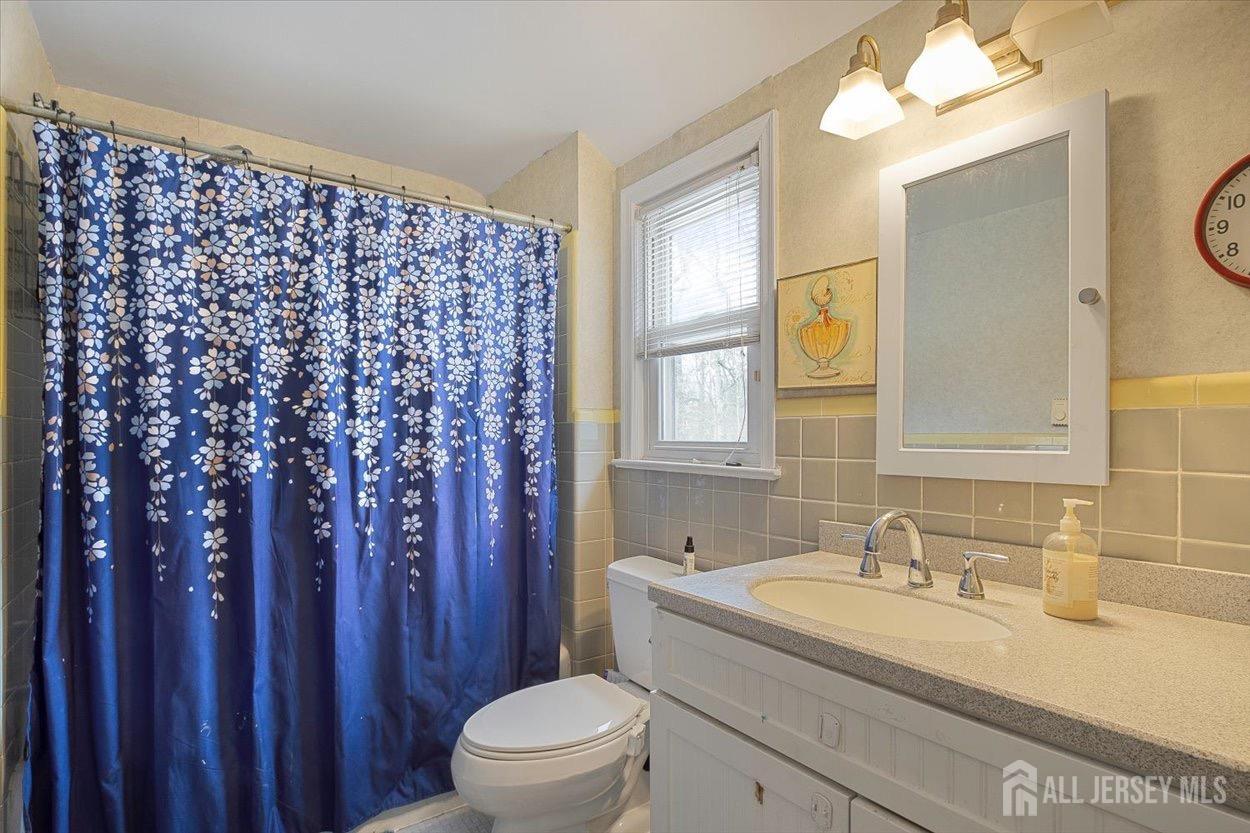 580 Schuyler Way Union, NJ 07083 - Photo 25 of 30 a bathroom with a granite countertop sink a toilet and a mirror