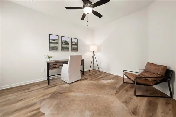 a spacious bedroom with a bed a table and a chandelier