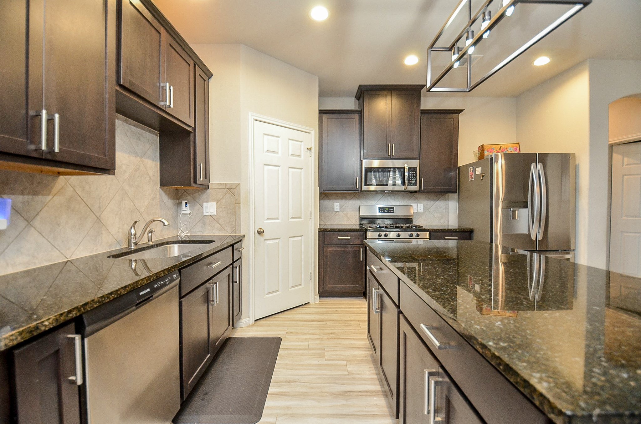 10519 Scrub Oak Drive Rosharon, TX 77583 - Photo 21 of 32 a kitchen with stainless steel appliances granite countertop a sink a stove and a refrigerator