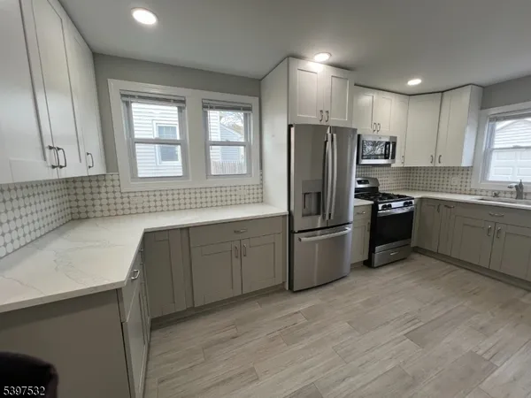 a kitchen with stainless steel appliances granite countertop a refrigerator and a sink
