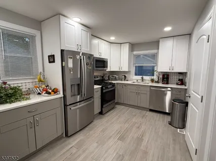 a kitchen with white cabinets and stainless steel appliances