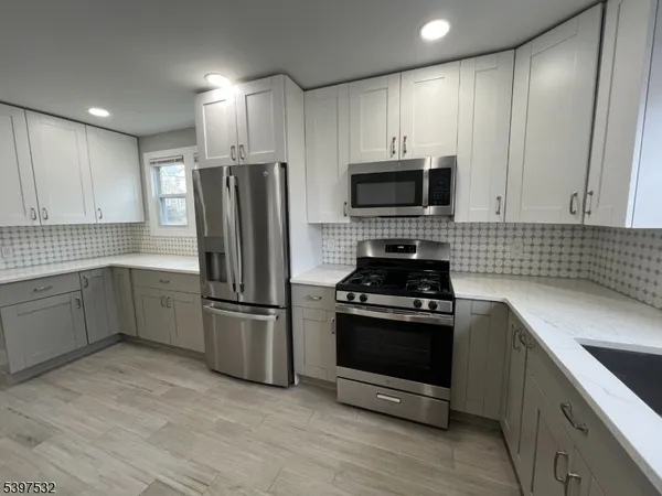 a kitchen with refrigerator a stove top oven a sink and dishwasher