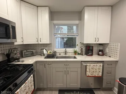 a kitchen with stainless steel appliances granite countertop a sink stove and cabinets