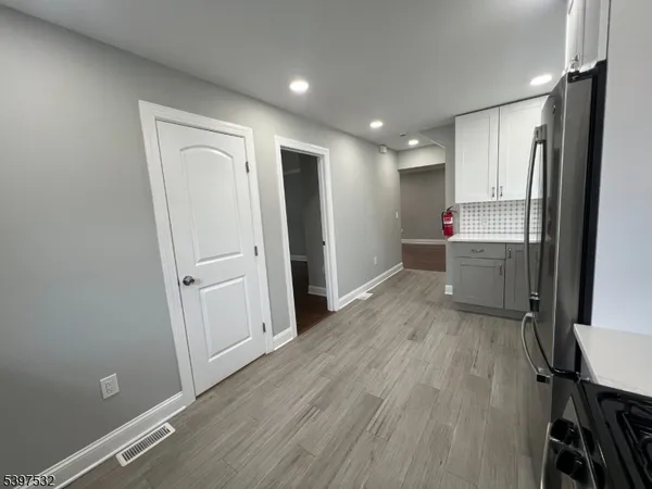 a view of kitchen with wooden floor electronic appliances and windows