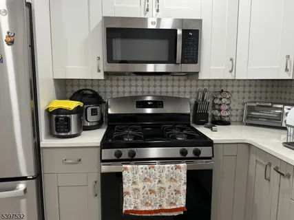 a kitchen with stainless steel appliances granite countertop a stove and a microwave